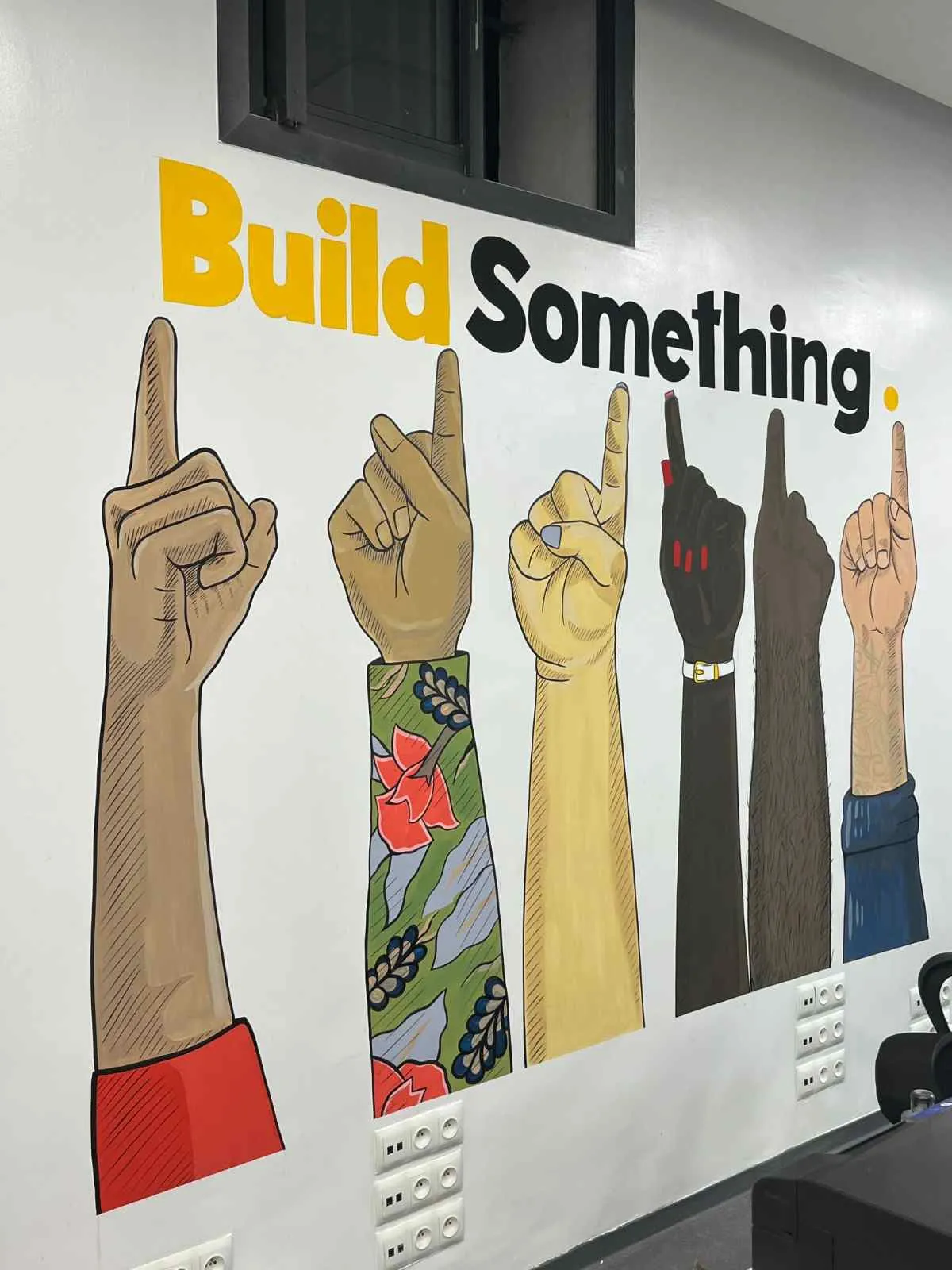 Fresque « Build Something » peinte dans un espace de travail